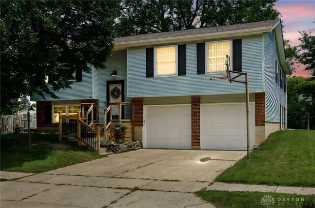 1817 El Camino Dr, Xenia, OH 45385 - split foyer home with a garage, concrete driveway, a lawn, and brick siding