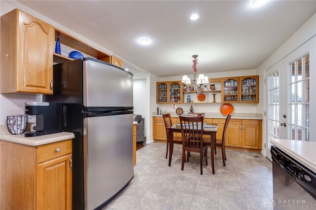 1817 El Camino Dr, Xenia, OH 45385 - kitchen with black dishwasher, a chandelier, open shelves, freestanding refrigerator, and glass insert cabinets