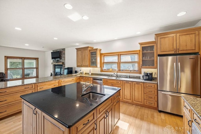 7373 Crowl Rd, Degraff, OH 43318 - kitchen with appliances with stainless steel finishes, a center island with sink, light wood finished floors, brown cabinetry, and recessed lighting