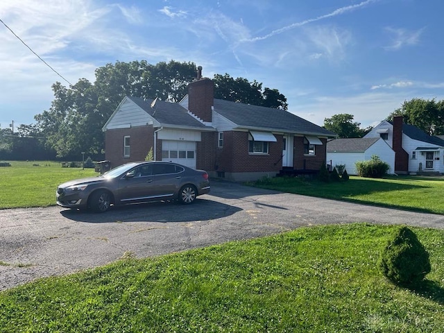 5747 N Springboro Pike, Dayton, OH 45449 - view of front facade featuring driveway, a garage, a chimney, brick siding, and a front yard