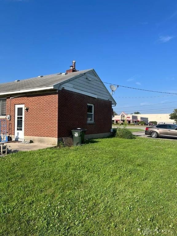 5747 N Springboro Pike, Dayton, OH 45449 - view of side of property featuring a lawn, a patio area, and brick siding