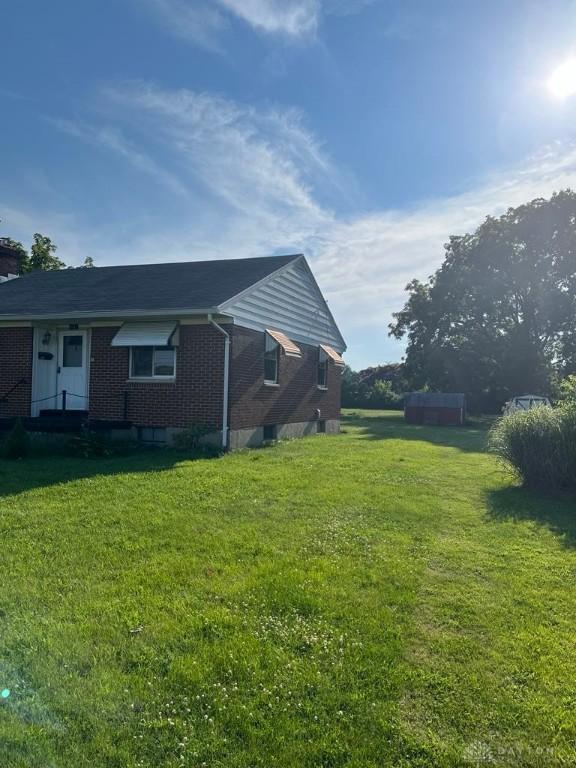 5747 N Springboro Pike, Dayton, OH 45449 - view of side of home with brick siding and a lawn