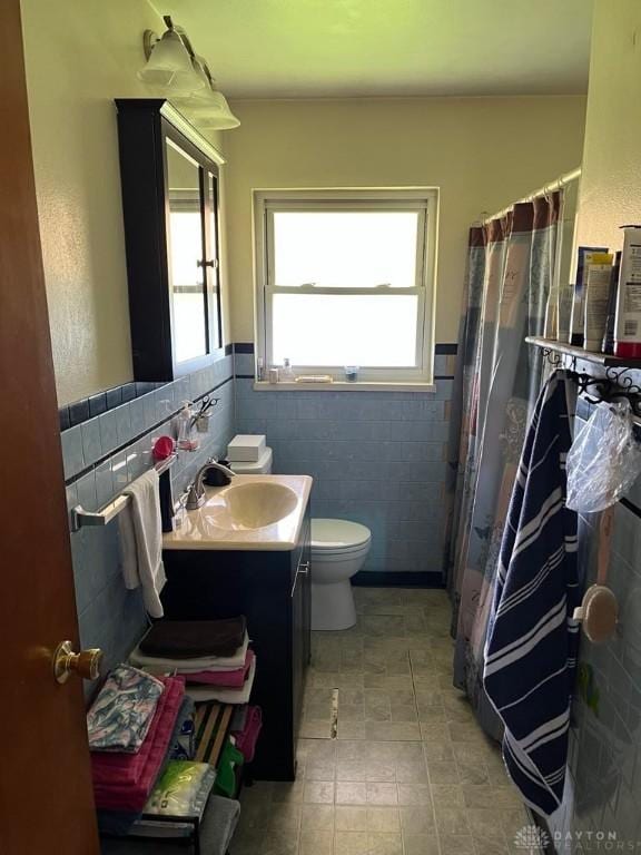 5747 N Springboro Pike, Dayton, OH 45449 - bathroom featuring tile walls, vanity, a shower with shower curtain, and wainscoting