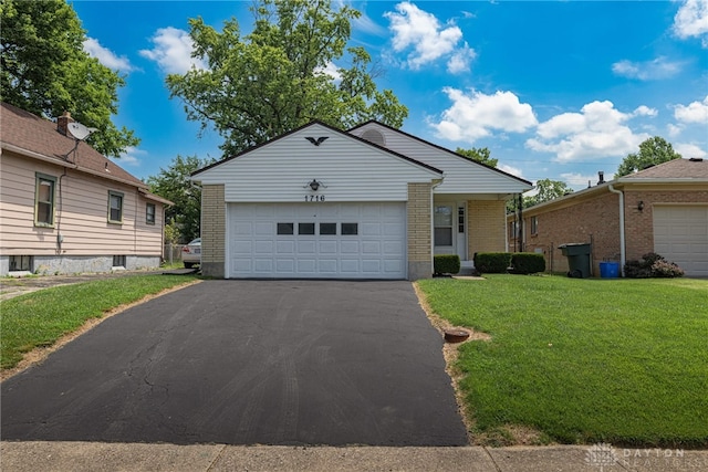 1716 Pershing Blvd, Dayton, OH 45420 - view of front of home with a front yard, an attached garage, brick siding, and driveway