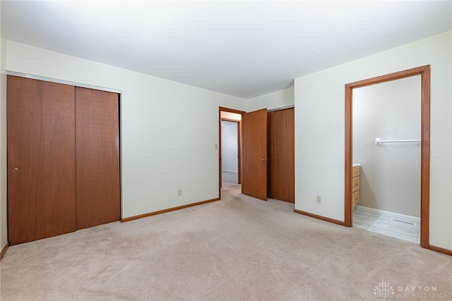 1716 Pershing Blvd, Dayton, OH 45420 - unfurnished bedroom with light carpet, connected bathroom, and multiple closets