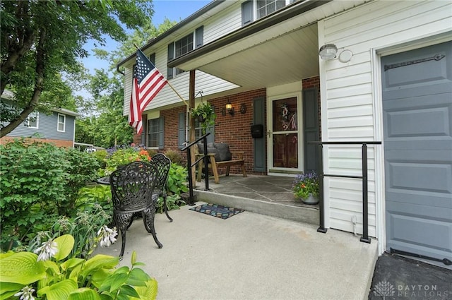 3811 Berryleaf Ct, Dayton, OH 45424 - property entrance featuring a porch, brick siding, and a garage