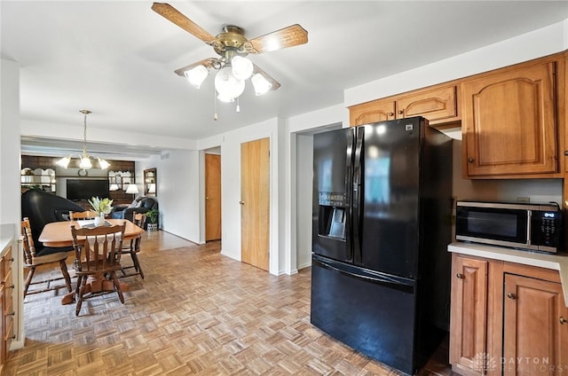 3811 Berryleaf Ct, Dayton, OH 45424 - kitchen featuring black fridge, stainless steel microwave, a ceiling fan, brown cabinetry, and light countertops