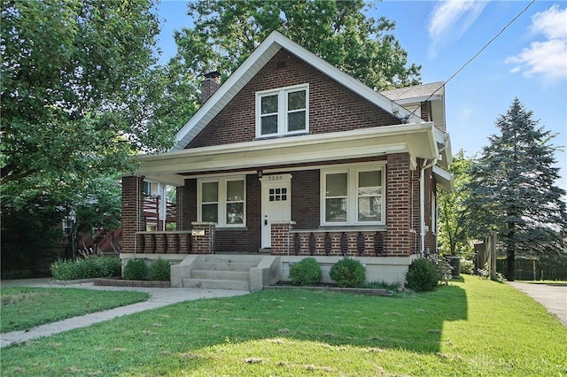 7336 Maple Ave, Cincinnati, OH 45231 - bungalow-style house with brick siding, a chimney, a front lawn, and a porch