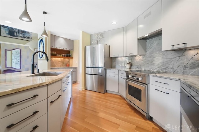 525 Heatherwoode Cir, Springboro, OH 45066 - kitchen with stainless steel appliances, decorative light fixtures, light wood-style flooring, light stone counters, and decorative backsplash