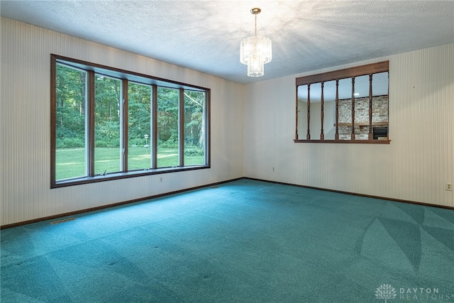 3072 Fowler Rd, Springfield, OH 45502 - empty room featuring a textured ceiling, healthy amount of natural light, carpet, and a chandelier