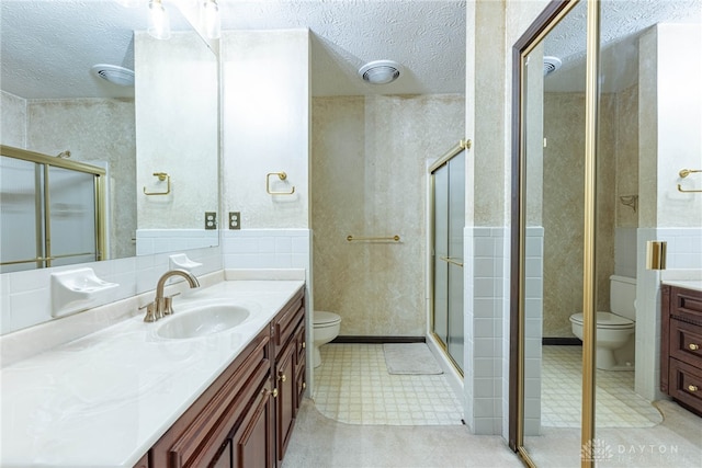 3072 Fowler Rd, Springfield, OH 45502 - bathroom with vanity, a textured ceiling, a stall shower, tile patterned floors, and a wainscoted wall