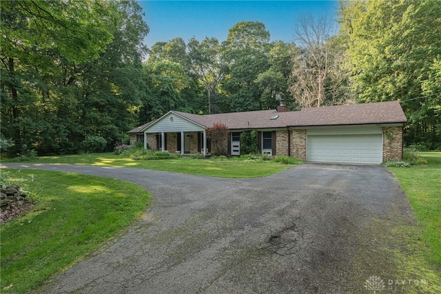 3072 Fowler Rd, Springfield, OH 45502 - ranch-style home featuring driveway, an attached garage, a front yard, a chimney, and brick siding