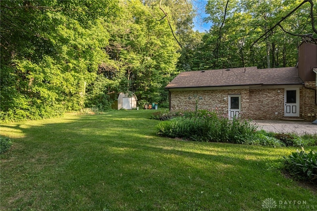 3072 Fowler Rd, Springfield, OH 45502 - view of grassy yard featuring a storage shed and a patio area