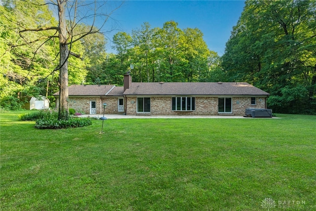 3072 Fowler Rd, Springfield, OH 45502 - ranch-style home with a hot tub, a chimney, a front yard, and a patio area