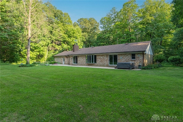3072 Fowler Rd, Springfield, OH 45502 - single story home with a hot tub, a chimney, a front lawn, and brick siding