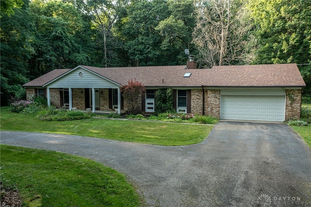 3072 Fowler Rd, Springfield, OH 45502 - single story home with driveway, a garage, a front lawn, and brick siding