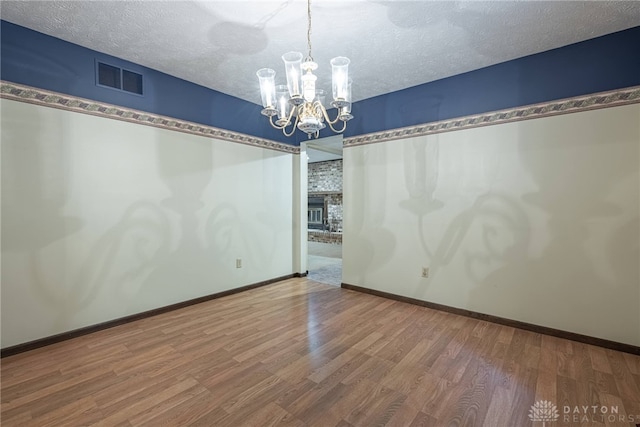 3072 Fowler Rd, Springfield, OH 45502 - spare room featuring a chandelier, wood finished floors, and a textured ceiling