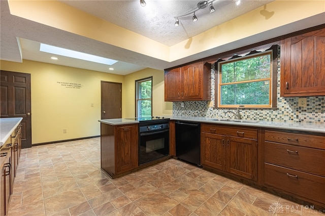 3072 Fowler Rd, Springfield, OH 45502 - kitchen featuring black appliances, a peninsula, tasteful backsplash, light countertops, and a textured ceiling