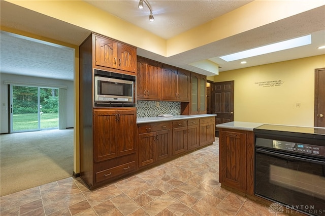 3072 Fowler Rd, Springfield, OH 45502 - kitchen featuring stainless steel microwave, black oven, light countertops, backsplash, and recessed lighting