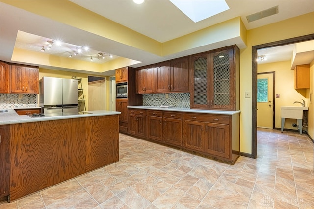 3072 Fowler Rd, Springfield, OH 45502 - kitchen featuring appliances with stainless steel finishes, a tray ceiling, and tasteful backsplash