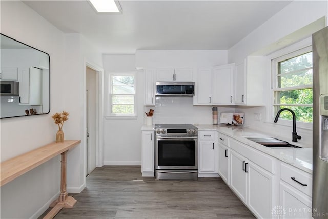 4651 Christopher Ave, Dayton, OH 45406 - kitchen with stainless steel appliances, light countertops, white cabinets, and decorative backsplash