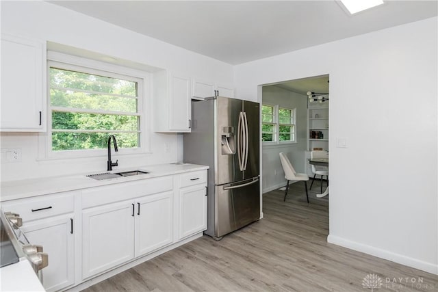 4651 Christopher Ave, Dayton, OH 45406 - kitchen featuring stainless steel fridge with ice dispenser, white cabinetry, light wood-style flooring, and light countertops