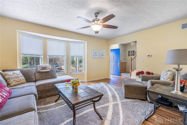 274 Tamarack Trl, Springboro, OH 45066 - living room with light wood-type flooring, a ceiling fan, a textured ceiling, and stairway