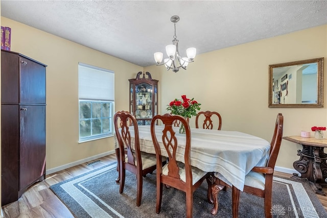 274 Tamarack Trl, Springboro, OH 45066 - dining room featuring a chandelier, wood finished floors, and a textured ceiling