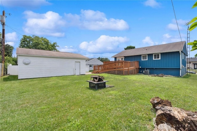 1220 Bookwalter Ave, New Carlisle, OH 45344 - view of grassy yard featuring a fire pit, a wooden deck, and an outbuilding