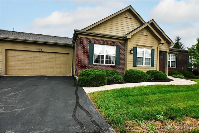 6963 Gentry Ln, Mason, OH 45040 - single story home with driveway, a garage, brick siding, and a front lawn