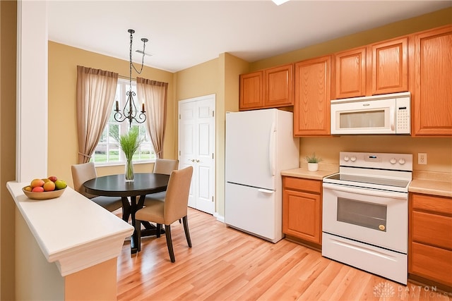 6963 Gentry Ln, Mason, OH 45040 - kitchen with white appliances, light wood-style flooring, light countertops, and pendant lighting