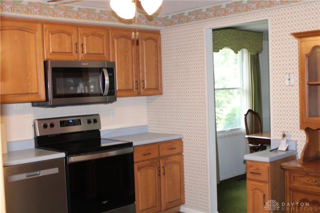 461 Poplar Grove Dr, Vandalia, OH 45377 - kitchen with stainless steel appliances, brown cabinetry, light countertops, decorative backsplash, and wallpapered walls