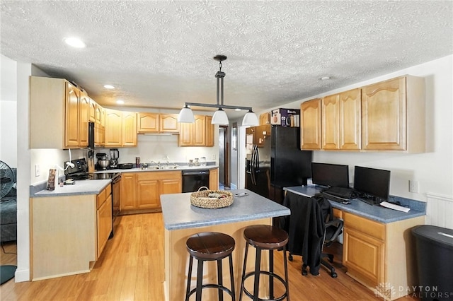 407 Overla Blvd, Englewood, OH 45322 - kitchen with black appliances, light wood-type flooring, a center island, a textured ceiling, and a kitchen bar