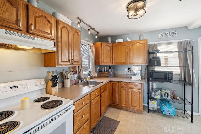 120 N Grant St, Covington, OH 45318 - kitchen with white electric range oven, under cabinet range hood, light countertops, and brown cabinetry