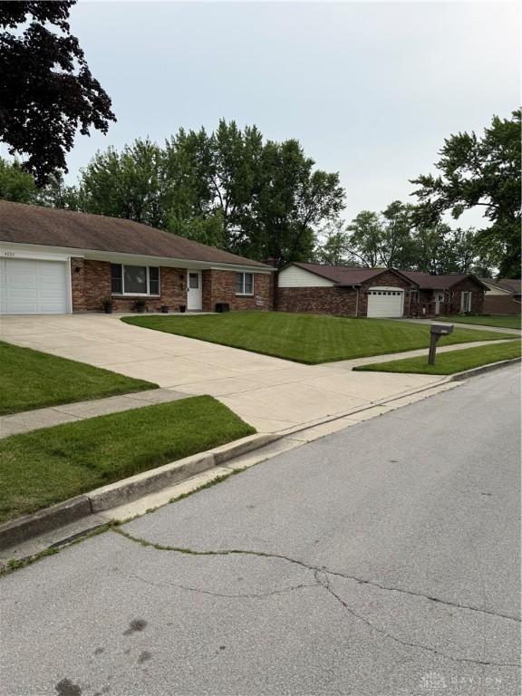 4220 Pleasanton Rd, Englewood, OH 45322 - ranch-style house with driveway, a garage, and a front yard