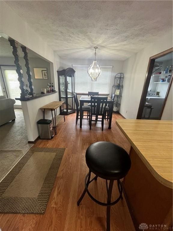 4220 Pleasanton Rd, Englewood, OH 45322 - dining area featuring plenty of natural light, a textured ceiling, a chandelier, and wood finished floors