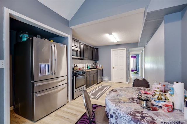 3521 E 4th St, Dayton, OH 45403 - kitchen featuring appliances with stainless steel finishes, light wood finished floors, lofted ceiling, and light countertops