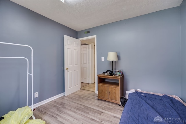 3521 E 4th St, Dayton, OH 45403 - bedroom with light wood finished floors and a textured ceiling
