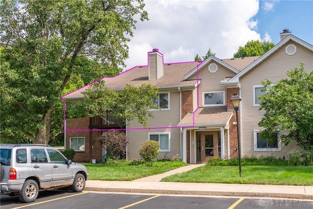 6600 Green Branch Dr Unit 5, Dayton, OH 45459 - view of front of home with uncovered parking, a chimney, a front yard, and brick siding