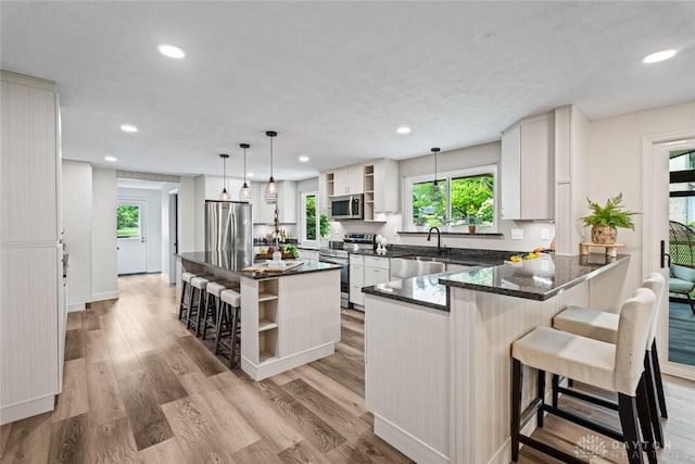 1695 Winterstone Ct, Washington Twp, OH 45458 - kitchen with open shelves, stainless steel appliances, recessed lighting, dark stone countertops, and a peninsula