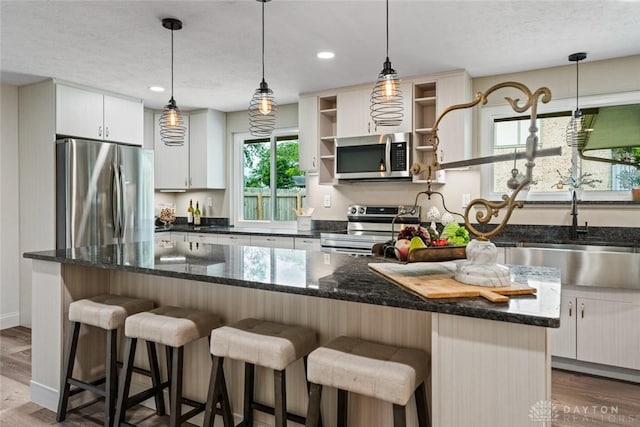 1695 Winterstone Ct, Washington Twp, OH 45458 - kitchen featuring stainless steel appliances, wood finished floors, white cabinets, hanging light fixtures, and recessed lighting