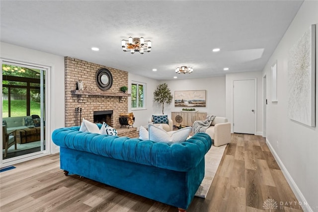 1695 Winterstone Ct, Washington Twp, OH 45458 - living room featuring a fireplace, wood finished floors, recessed lighting, and a chandelier
