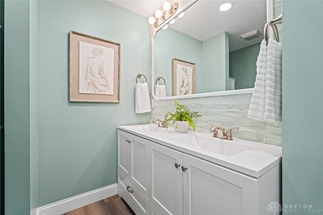 1695 Winterstone Ct, Washington Twp, OH 45458 - bathroom featuring double vanity, wood finished floors, and tasteful backsplash
