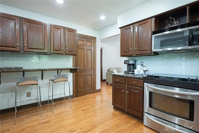 1908 Court Donegal, Middletown, OH 45042 - kitchen with stainless steel appliances, tasteful backsplash, dark stone counters, a kitchen bar, and recessed lighting