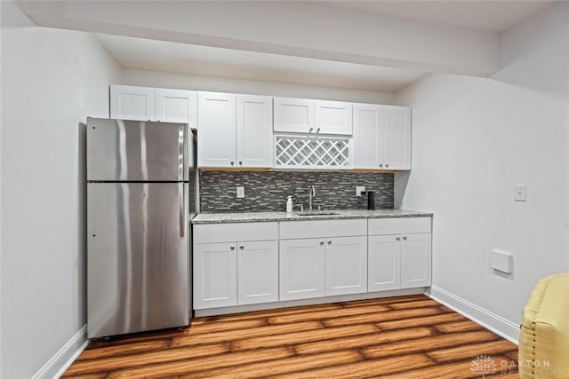 2073 Lincolnshire Dr, Beavercreek, OH 45434 - kitchen with freestanding refrigerator, decorative backsplash, dark wood-style floors, white cabinets, and light stone countertops