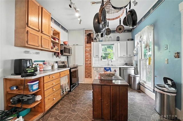116 Elm St, Franklin, OH 45005 - kitchen with appliances with stainless steel finishes, open shelves, stone floors, and a center island