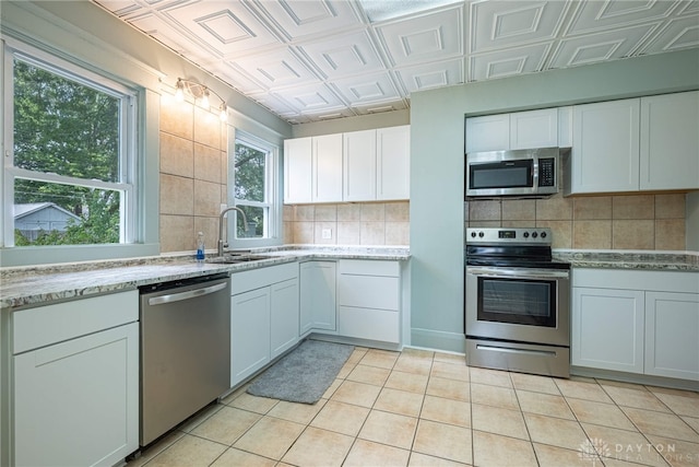 19 Mckinley St, Middletown, OH 45042 - kitchen with appliances with stainless steel finishes, an ornate ceiling, tasteful backsplash, light tile patterned floors, and white cabinetry