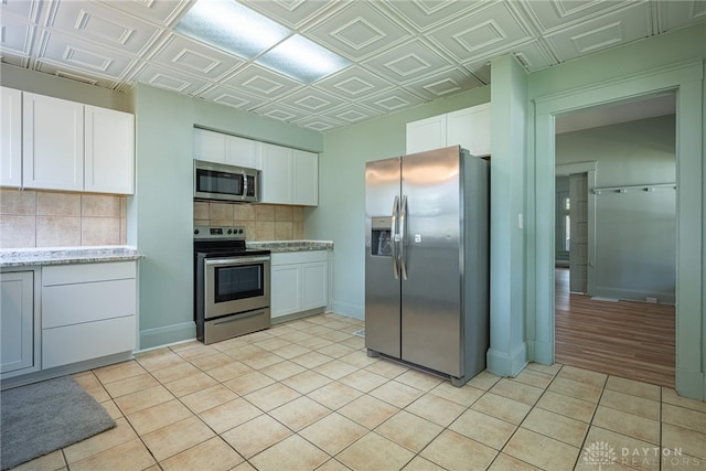 19 Mckinley St, Middletown, OH 45042 - kitchen featuring appliances with stainless steel finishes, tasteful backsplash, white cabinetry, light tile patterned floors, and an ornate ceiling
