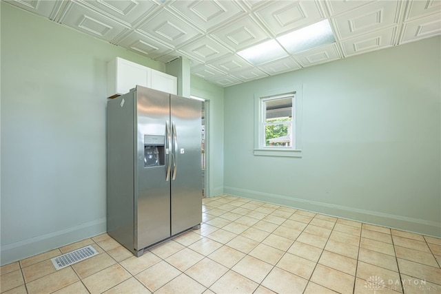 19 Mckinley St, Middletown, OH 45042 - kitchen with stainless steel fridge, white cabinetry, an ornate ceiling, and light tile patterned flooring
