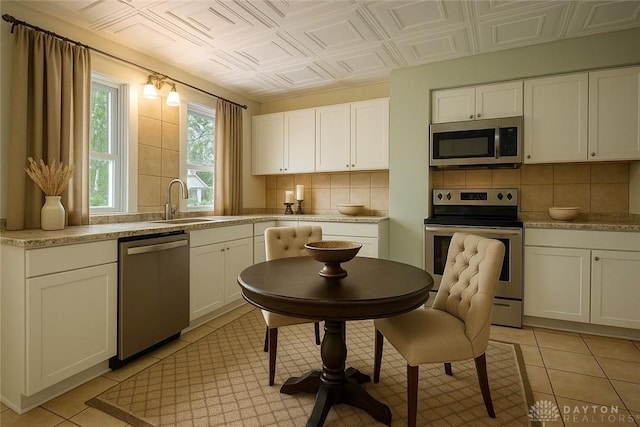 19 Mckinley St, Middletown, OH 45042 - kitchen with appliances with stainless steel finishes, decorative backsplash, white cabinetry, and an ornate ceiling